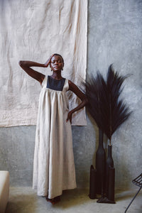 Model wearing Butterfly Linen dress standing next to a black vase with black feather